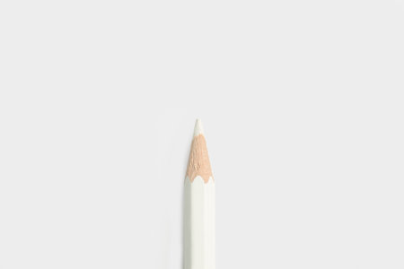 White pencil on a gray background with copy space