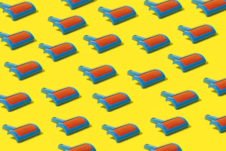 Plastic pet hairbrushes on a yellow backgroundの写真素材