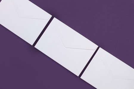 White envelopes on a purple background with copy spaceの写真素材