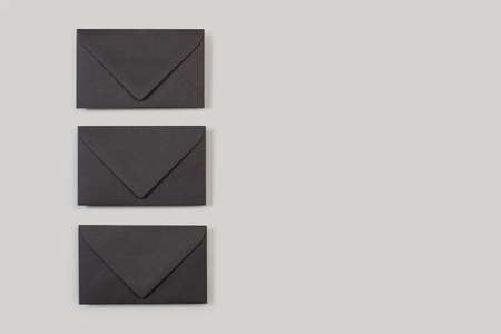 Black envelopes on a gray background in a top view