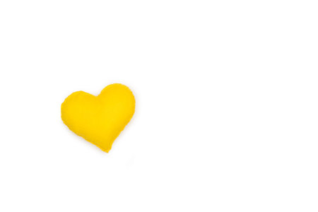 A fabric yellow heart on a white background with copy spaceの写真素材