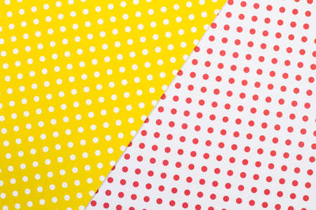 A yellow and white paper background with white and red polka dotsの写真素材