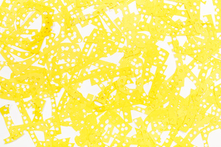 Yellow paper scraps from making confetti on a white background