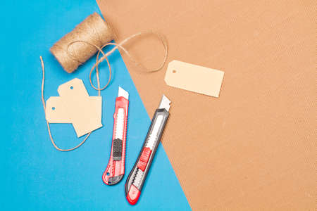 Cutters and cardboard labels on a brown and blue background with copy spaceの写真素材
