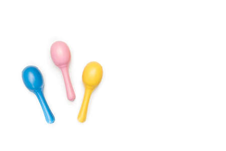 Three colored maracas on a white background with copy space