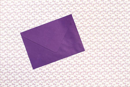 A purple envelope on a purple flowers background with copy space
