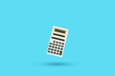 A calculator floating on a blue background with a copy spaceの写真素材