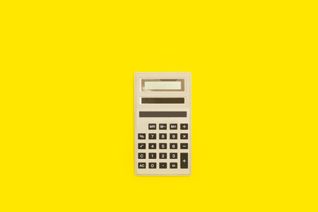 A calculator on a yellow background with a copy spaceの写真素材