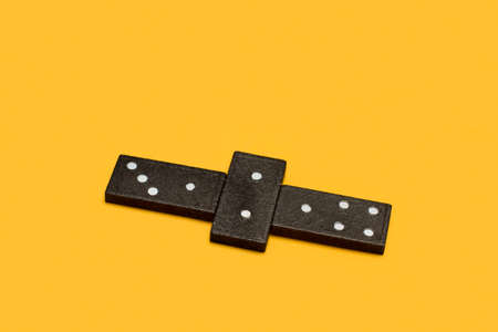Domino pieces on a yellow background in a top view