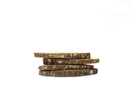 A pile of tree trunk slices on a white background with copy space