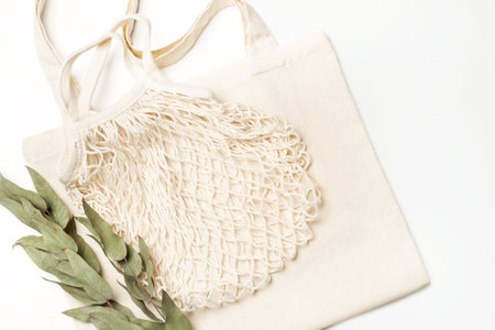A blank white tote bag and a cotton mesh bag on a white backgroundの写真素材
