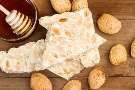Almond nougat in pieces on a wooden background in a top viewの写真素材