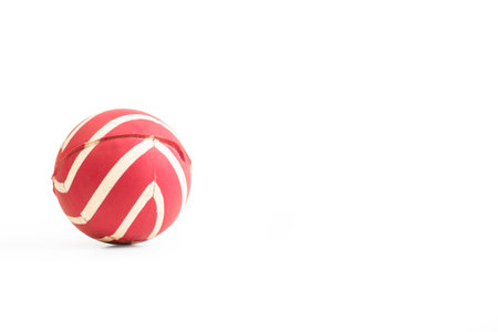 Striped red and white rubber ball isolated on a white background with copy space
