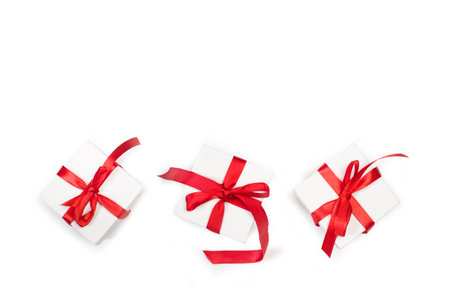 Three white boxes with red bows on a white background with copy spaceの写真素材