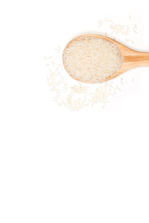 Raw rice in a wooden spoon and on a white background with copy spaceの写真素材