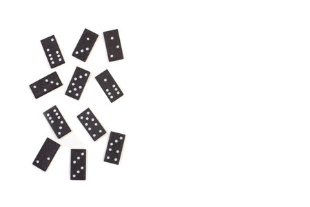 Black domino pieces on a white background with copy space in a top up view