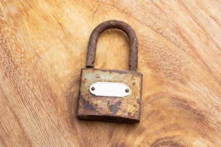 A rusty open padlock on a wooden table in a top viewの写真素材