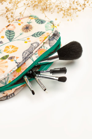 Make up bag with make up brushes on a white background with copy space