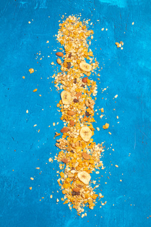 A heap of granola on a blue background with copy spaceの写真素材
