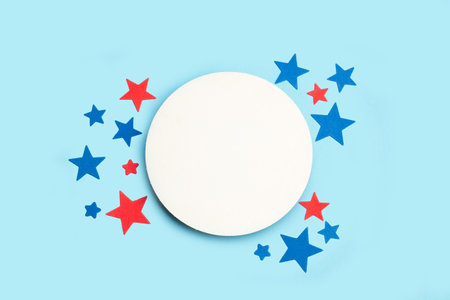 Blue and red stars and a round blank white copy space on a light blue background in a top viewの写真素材