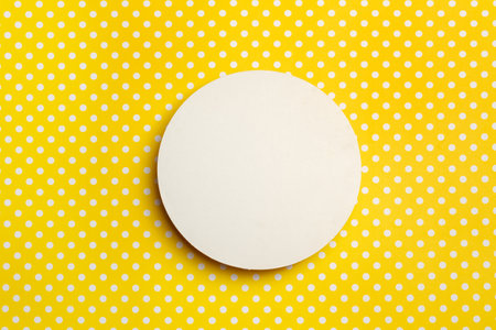 A blank round copy space on a yellow background with white dots in a top view
