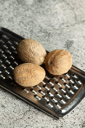 Nutmegs and a grater on a marble kitchen counter with copy spaceの写真素材