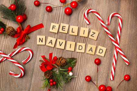 Merry christmas phrase made with wooden letter blocks and christmas ornaments on a wooden backgroundの写真素材