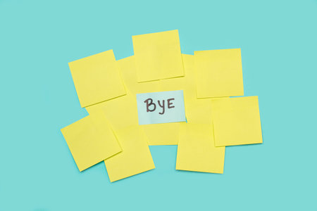 Bye single word handwritten on a light blue sticky paper on yellow blank sticky papers on a light blue backgroundの写真素材