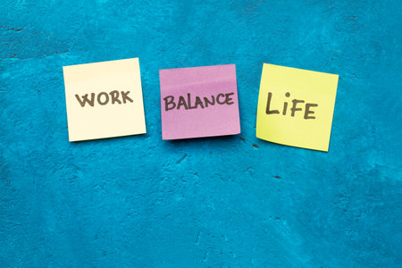 Work, balance and life single words handwritten on colored sticky papers on a blue background with...