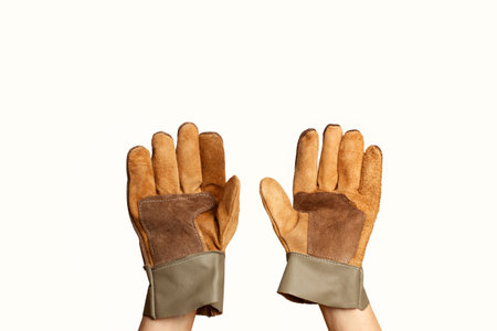 Man hands wearing brown leather work gloves on a white background with copy spaceの写真素材
