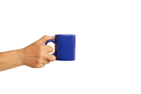 Hand holding a blue mug on a white background with copy spaceの写真素材