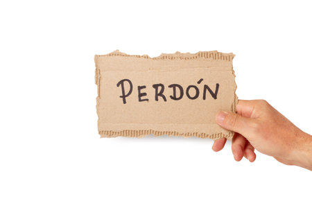 Man hand holding a piece of cardboard with pardon word written on it on a white background (trad. sorry)の写真素材
