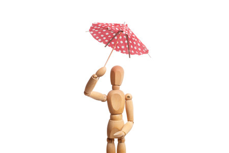 A wooden mannequin toy holding an umbrella in his hand on white backgroundの写真素材