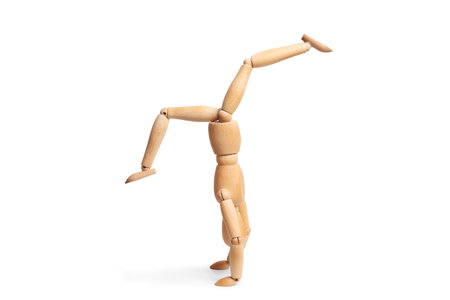 A wooden mannequin doing a handstand on white background with copy spaceの写真素材