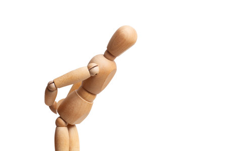 A wooden mannequin touching his waist on white background with copy spaceの写真素材