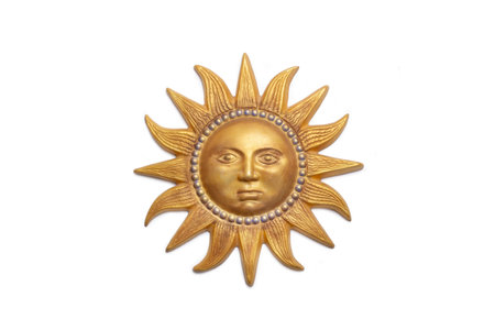 A golden ceramic sun with a human face isolated on a white backgroundの写真素材