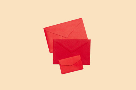 Three red envelopes on a beige background with copy spaceの写真素材
