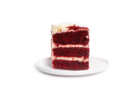 A piece of red velvet cake on a white plate isolated on a white background with copy space