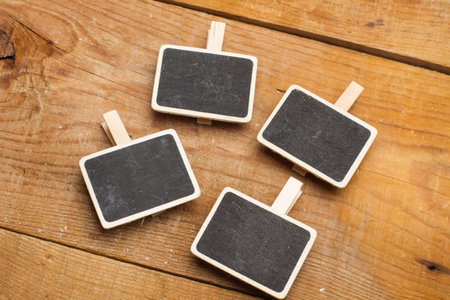 Four small blackboards on a wooden table in a top viewの写真素材