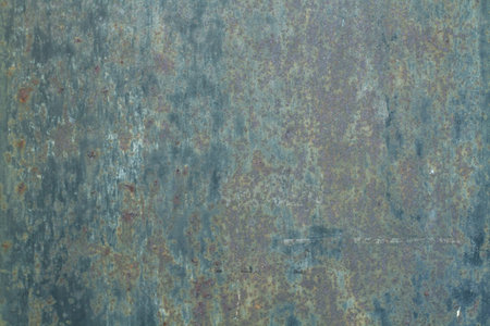 A metal background with paint in poor condition and rust in a close up view