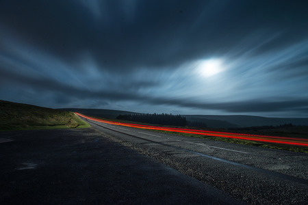 blur night shoot of fast driving car with blured clouds
