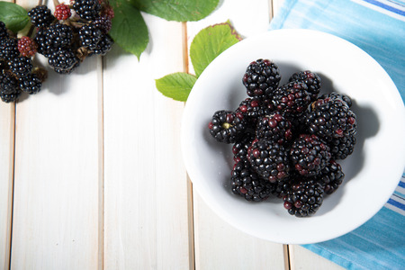 fresh organic blackberries on plate  on white background retro kitchen table