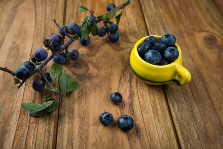 fresh blueberries on kitchen wooden table with yellow potの写真素材