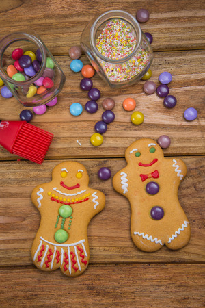 Home made gingerbread men decorating for Christmas on wooden backgroundの写真素材