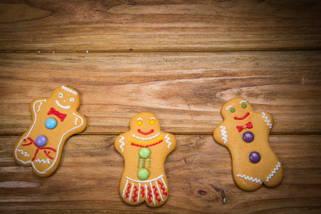Home made gingerbread men decorating for Christmas on wooden backgroundの写真素材