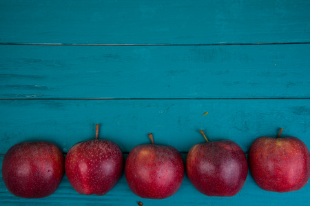 Farm fresh organic red  apples on wooden table in pastel color with copy space in backgroundの写真素材