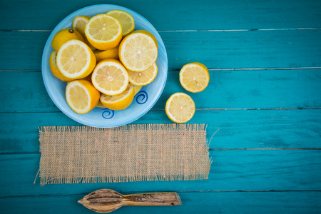 Market fresh organic lemons halves on wooden table background with copy space and juice squeezerの写真素材