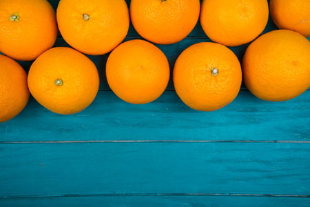 Fresh organic oranges fruits on blue wooden background with copy spaceの写真素材