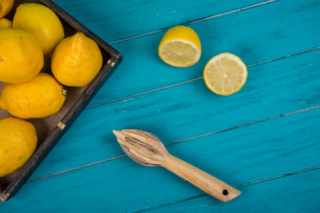Fresh organic lemons and squeezer for homemade juice on wooden table backgroundの写真素材
