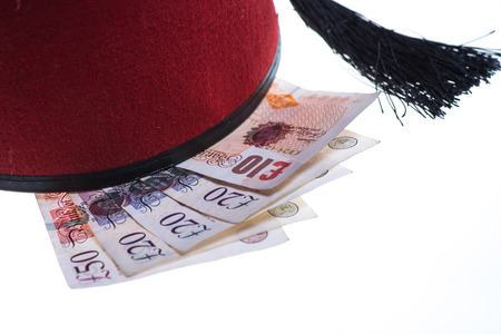 hotel boy hat and british money isolated on white